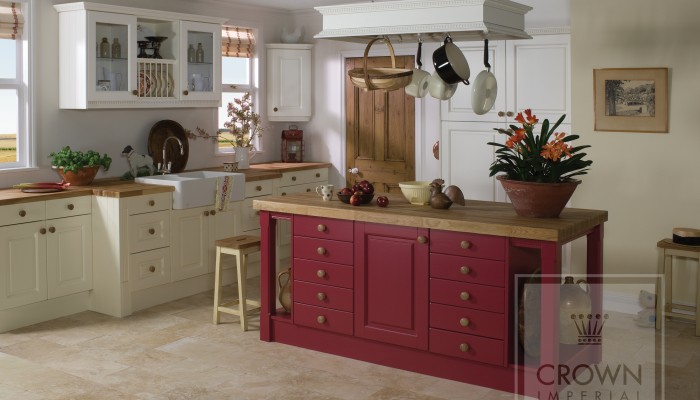 Interior image of kitchen with red painted island and oyster painted cabinetry