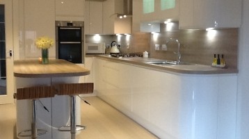 Image of renovated kitchen with white cabinets, wood and grey accents